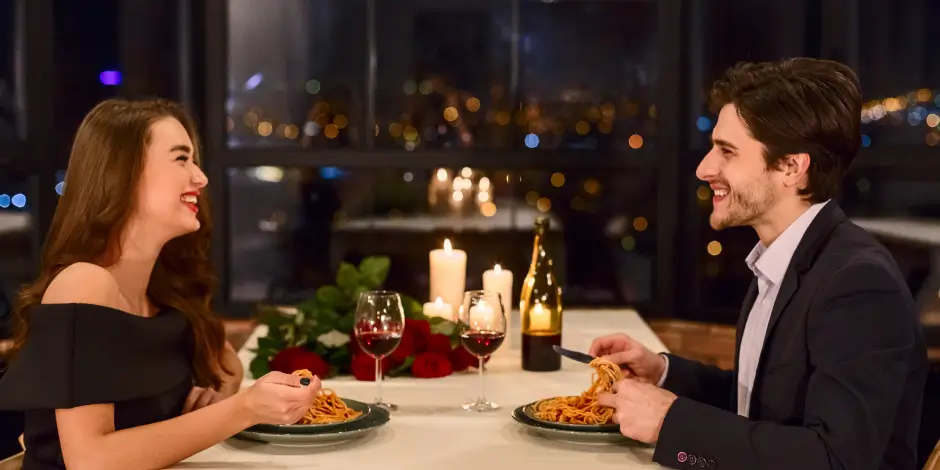 Ein Paar sitzt in einem schicken Restaurant und lacht gemeinsam bei einem Date.